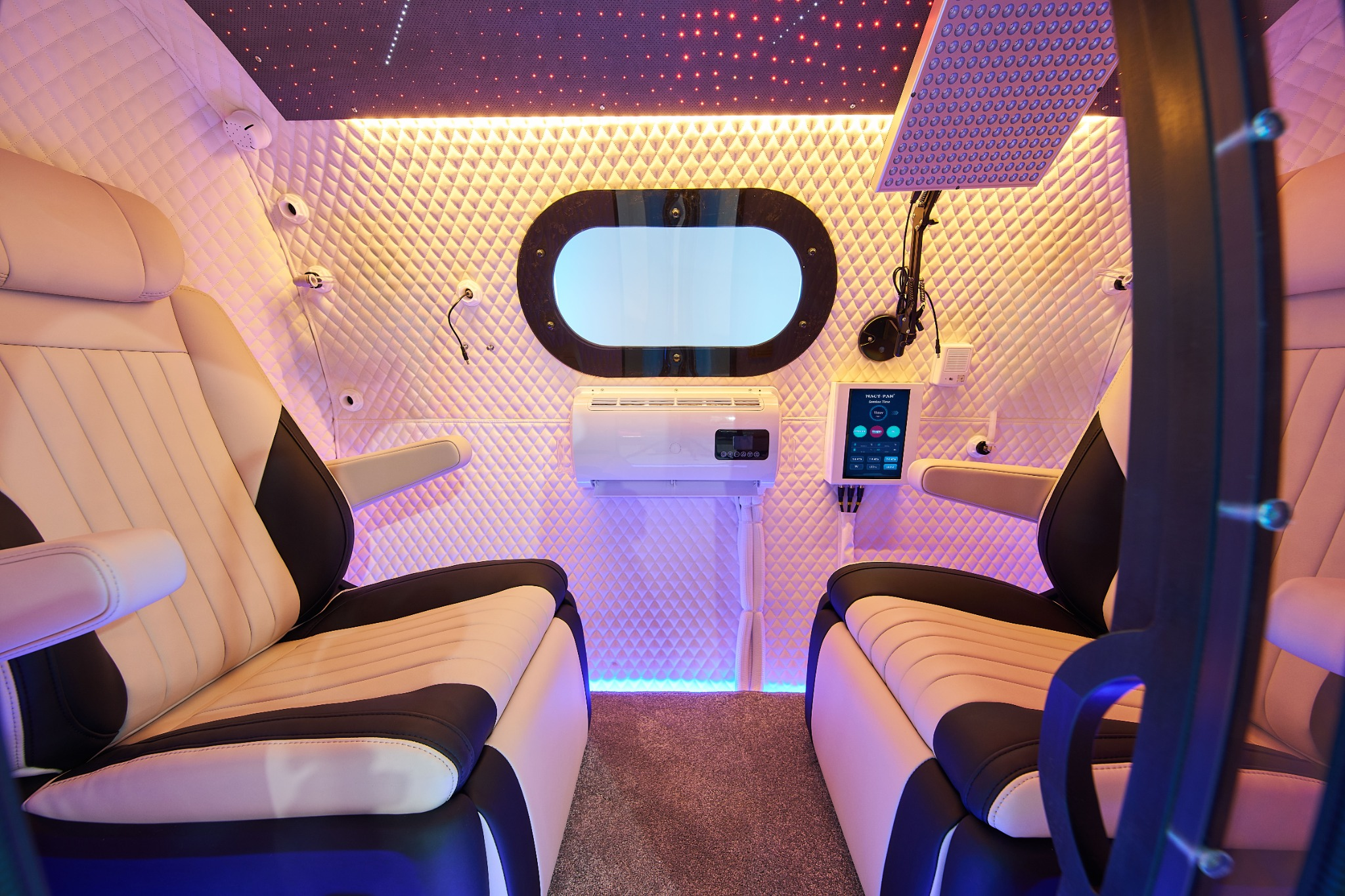 GenZen cabin with opposing reclining seats, quilted walls, and lighting